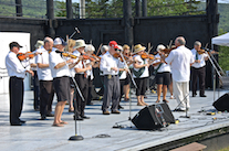 The Feisty Fiddlers— The Cape Breton University Seniors Fiddling Group, directed by Eddie Rogers and accompanied by Leanne Aucoin on keyboard