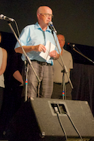 Bob MacEachern, speaking for the Cape Breton Fiddlers’ Association in the company of three living founders of the Association and many members of its current Board of Directors, welcomes those present