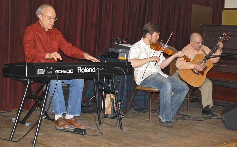 Photo of Doug Lamey on fiddle accompanied by Lloyd Carr on keyboards and Michael Kerr on guitar