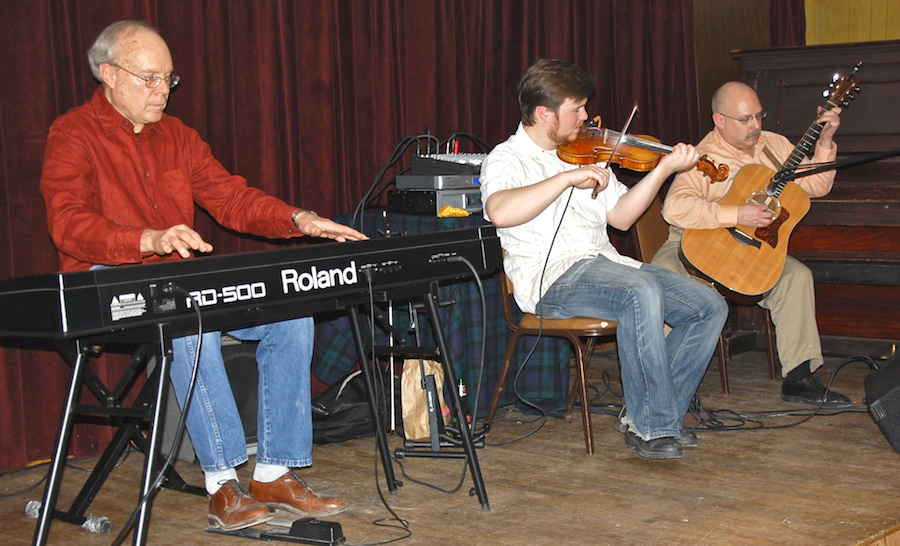 Photo of Doug Lamey on fiddle accompanied by Lloyd Carr on keyboards and Michael Kerr on guitar