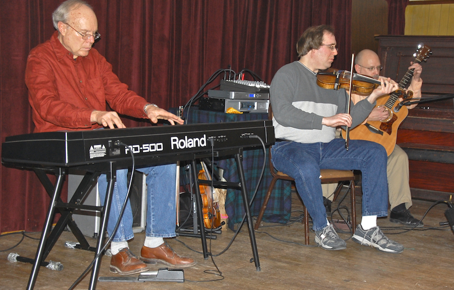 Photo of Gordon Aucoin on fiddle accompanied by Lloyd Carr on keyboards and Michael Kerr on guitar