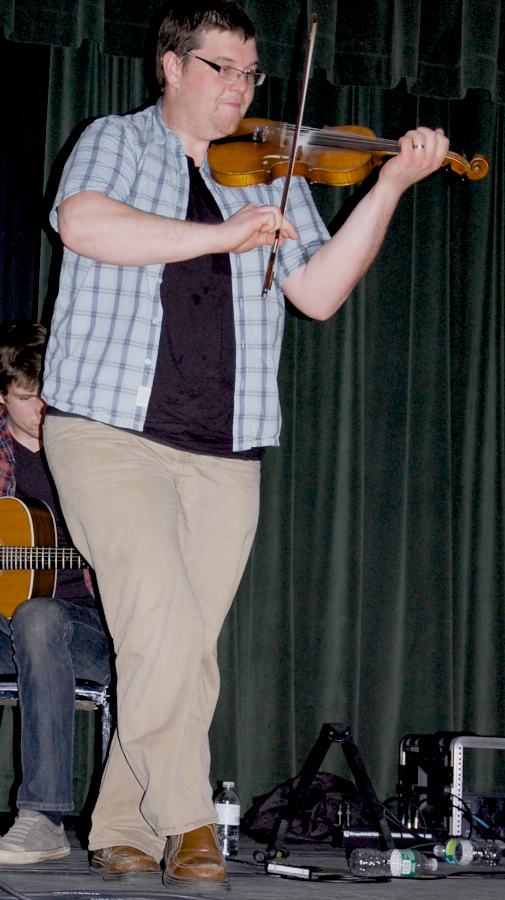 Photo of J. J. Chaisson step-dancing and playing the fiddle