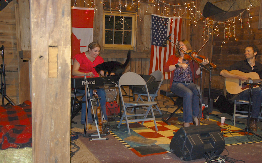 Photo of Wendy MacIsaac on fiddle accompanied by Andrea Beaton on keyboards and Seph Peters on guitar<br>as the Black Cat joins Andrea on the keyboards