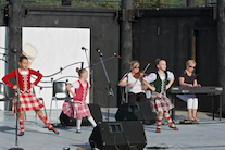 Emma MacNeil, Amelie Bates, and Mia Nordine dancing a Highland Fling to the music of Dara Smith-MacDonald on fiddle and Betty Lou Beaton on keyboard